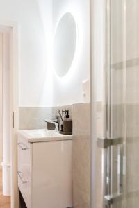 Baño blanco con lavabo y espejo en Deluxe Flat, PS4, Parken, Netflix, Zentral en Offenbach