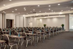 an empty room with tables and chairs in a hall at HYPERION Hotel Hamburg in Hamburg