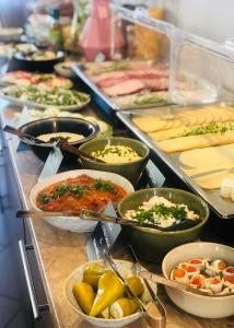una línea de buffet con muchos tipos diferentes de comida en Azalia, en Ustronie Morskie