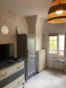 a living room with a refrigerator and a window at Maison d'hôtes Il était une fois in Pont-lʼÉvêque