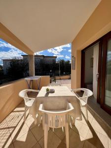 a patio with a table and chairs on a balcony at Appartamento La Conchiglia a pochi passi dal centro in San Teodoro