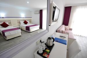 a small room with two beds and a mirror at Ramira Beach Hotel - All Inclusive in Avsallar