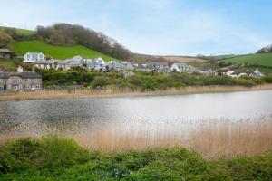 a large body of water with houses in the background at Swan's Nest in Torcross