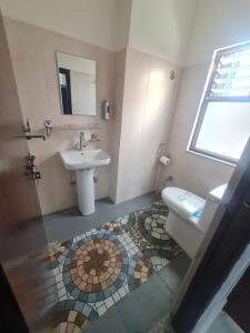 ein Bad mit einem Waschbecken und einem WC in der Unterkunft Hotel Homestay Inn in Thimi