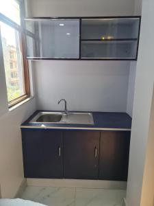uma cozinha com um lavatório e um micro-ondas em Hotel Homestay Inn em Thimi