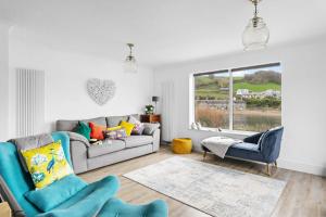 a living room with a couch and chairs and a window at Swan's Nest in Torcross