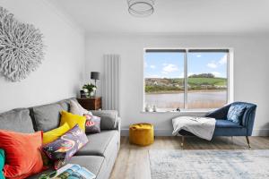 a living room with a couch and a window at Swan's Nest in Torcross
