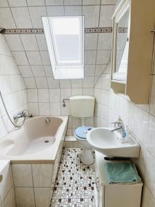 a bathroom with a toilet and a sink and a tub at Messezimmer Laatzen 30880 in Hannover