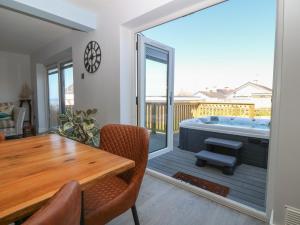 a living room with a table and a tub on a deck at Melody in Cemaes Bay