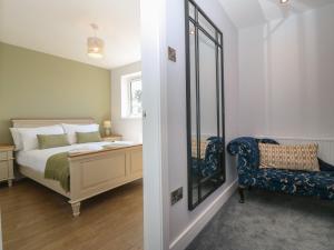 a bedroom with a bed and a chair and a mirror at Melody in Cemaes Bay