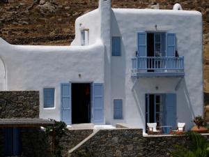 a white house with blue windows and a balcony at Nama Villas in Super Paradise Beach