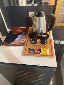 a counter top with a coffee pot and snacks on it at Exporoyal Hotel in Antalya