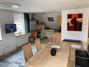 a living room with a wooden table and a kitchen at Ferienwohnung Kellerer 2 in Waischenfeld
