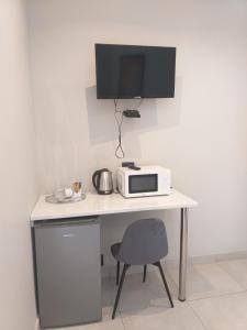 escritorio blanco con microondas y TV en Kanyane @ Graskop en Graskop