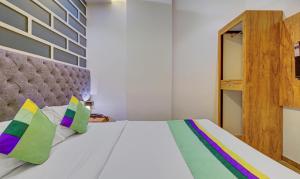sypialnia z białym łóżkiem i kolorowymi poduszkami w obiekcie Treebo Trend Prince, Mumbai w Bombaju