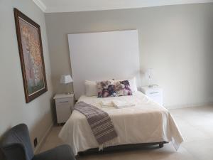 Un dormitorio blanco con una cama con animales de peluche. en Kanyane @ Graskop en Graskop