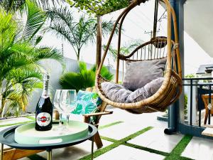 a swinging chair on a balcony with a bottle of wine at Ultraluxurious HolidayVilla with an Infinity Pool in Apenkwa