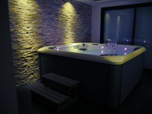a bathroom with a tub with lights in it at Gîte Il était une fois in Bourgbarré