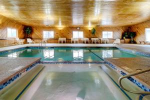 a indoor swimming pool with tables and chairs at Quality Inn & Suites in Lincoln