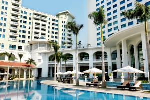 un hotel con piscina, palmeras y sombrillas en Daeha Serviced Apartment, en Hanói