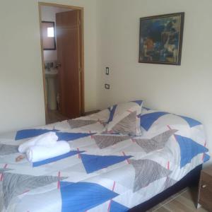 1 cama con edredón y almohadas azules y blancos en Casa Hotel Castellón en Hispania