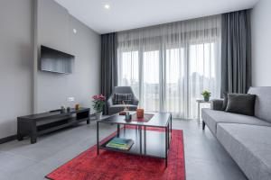 uma sala de estar com um sofá e uma mesa em Rose Residence - Trendy Apartments Near The Beach em Antalya