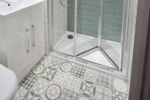 La salle de bains est pourvue d'une douche avec une porte en verre. dans l'établissement Comfort Inn Victoria, à Londres