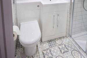 a bathroom with a white toilet and a sink at Comfort Inn Victoria in London