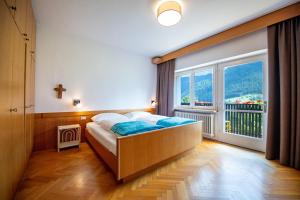 a bedroom with a bed and a large window at Apartment Murata in Ortisei
