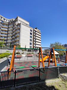een speeltuin met een glijbaan voor een gebouw bij Anika Sweet Apartment at Vodno in Skopje
