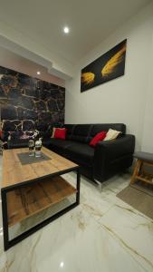 a living room with a black couch and a table at Diamond Apartment Piran FREE PARKING in Piran