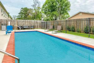 a swimming pool in a backyard with a fence at Days Inn by Wyndham Zachary LA in Zachary