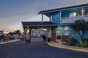 un bâtiment bleu avec un panneau devant lui dans l'établissement Oceanside Inn & Suites, a Days Inn by Wyndham, à Fort Bragg