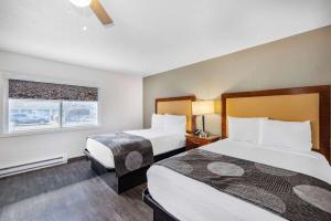 a hotel room with two beds and a window at Oceanside Inn & Suites, a Days Inn by Wyndham in Fort Bragg