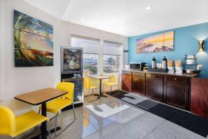 Habitación con cocina con sillas amarillas y mesa. en Oceanside Inn & Suites, a Days Inn by Wyndham, en Fort Bragg