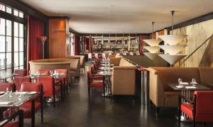 un restaurante con mesas y sillas y un bar en The Chatwal, The Unbound Collection by Hyatt en Nueva York