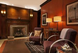 a living room with chairs and a fireplace at The Chatwal, The Unbound Collection by Hyatt in New York