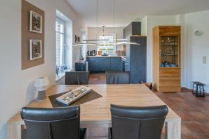 Un comedor y una cocina con mesa y sillas de madera. en Leuchtturm, en Dornumergrode
