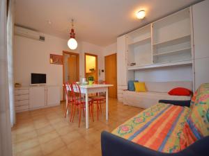 un soggiorno con letto, tavolo e sedie di Appartamenti Verdemare a Lignano Sabbiadoro