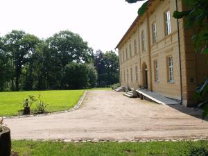 a large building with a dirt driveway in front of it at Landhaus Schloss Kölzow in Kölzow