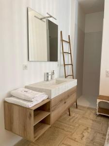 a bathroom with a sink and a mirror at La Maison du Puits in Cesseras