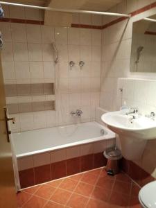 Helles und großzügiges Souterrain Appartement في التنماركت ام بونغاو: حمام مع حوض استحمام ومغسلة