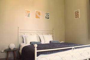 una camera con letto bianco e cuscini di il nuvoloso a Città della Pieve