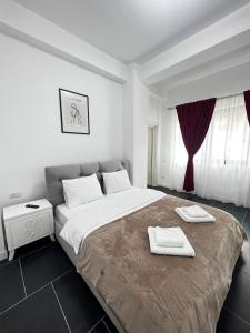 a bedroom with a large bed with two towels on it at Luxury Cozy Apartments - City Center Suceava in Suceava