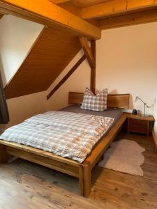 Cama en habitación con techo de madera en Sonniges Ferienapartment am Alten Binauer Schloss, 