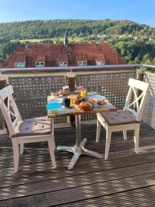 a table and two chairs on a balcony with a meal at Sonniges Ferienapartment am Alten Binauer Schloss 
