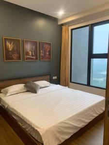 um quarto com uma cama grande e uma janela grande em Sky Oasis 2 Room 2wc Homestay Ecopark em Hanói