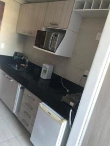 uma cozinha com um balcão preto e um micro-ondas em MAR DO CABO BRANCO YELLOW residence em João Pessoa