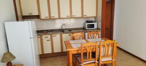 a kitchen with a wooden table and a microwave at LAGO AZUL 45 in Breña Baja