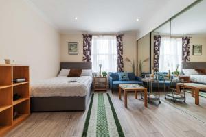 a bedroom with a bed and a living room at Elegant Art Deco whole apartment 2mins to Hyde Park, 8mins to Bayswater, Nottinghill, Paddington in London